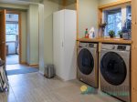 Mudroom with front loading washer and dryer. There is a picnic basket for guest use.